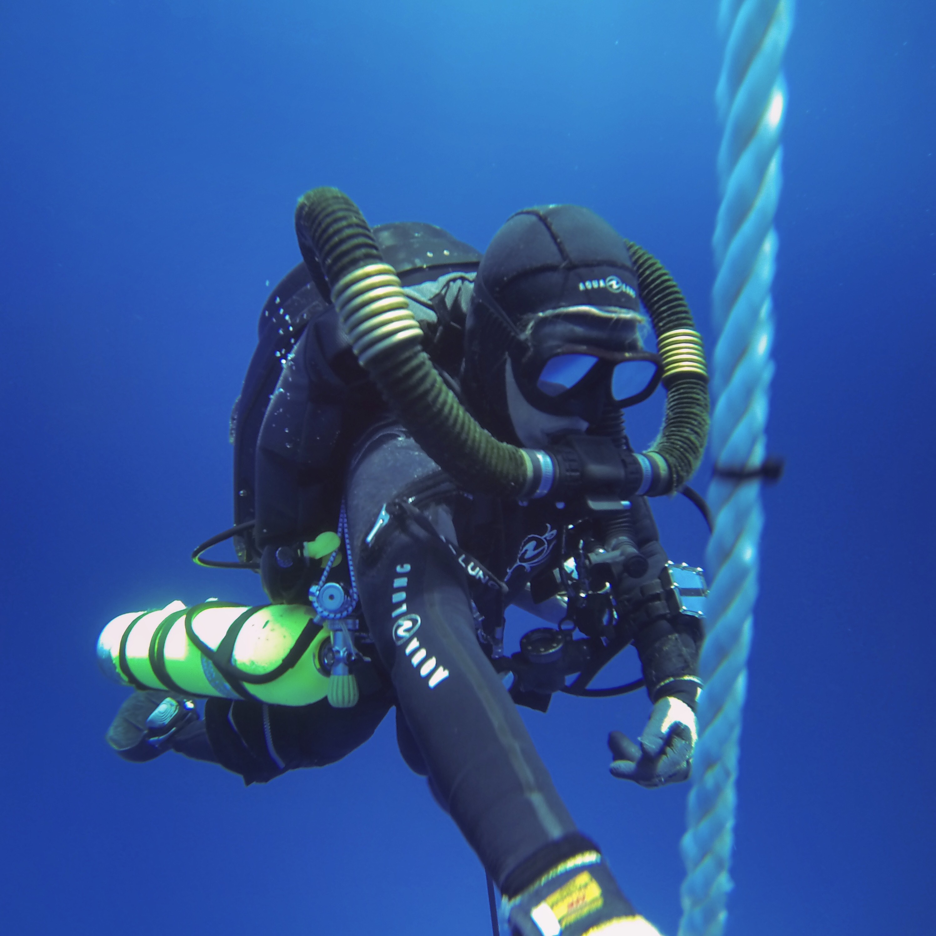 Tiffany Winn on a rebreather, holding a shot line in open blue water.