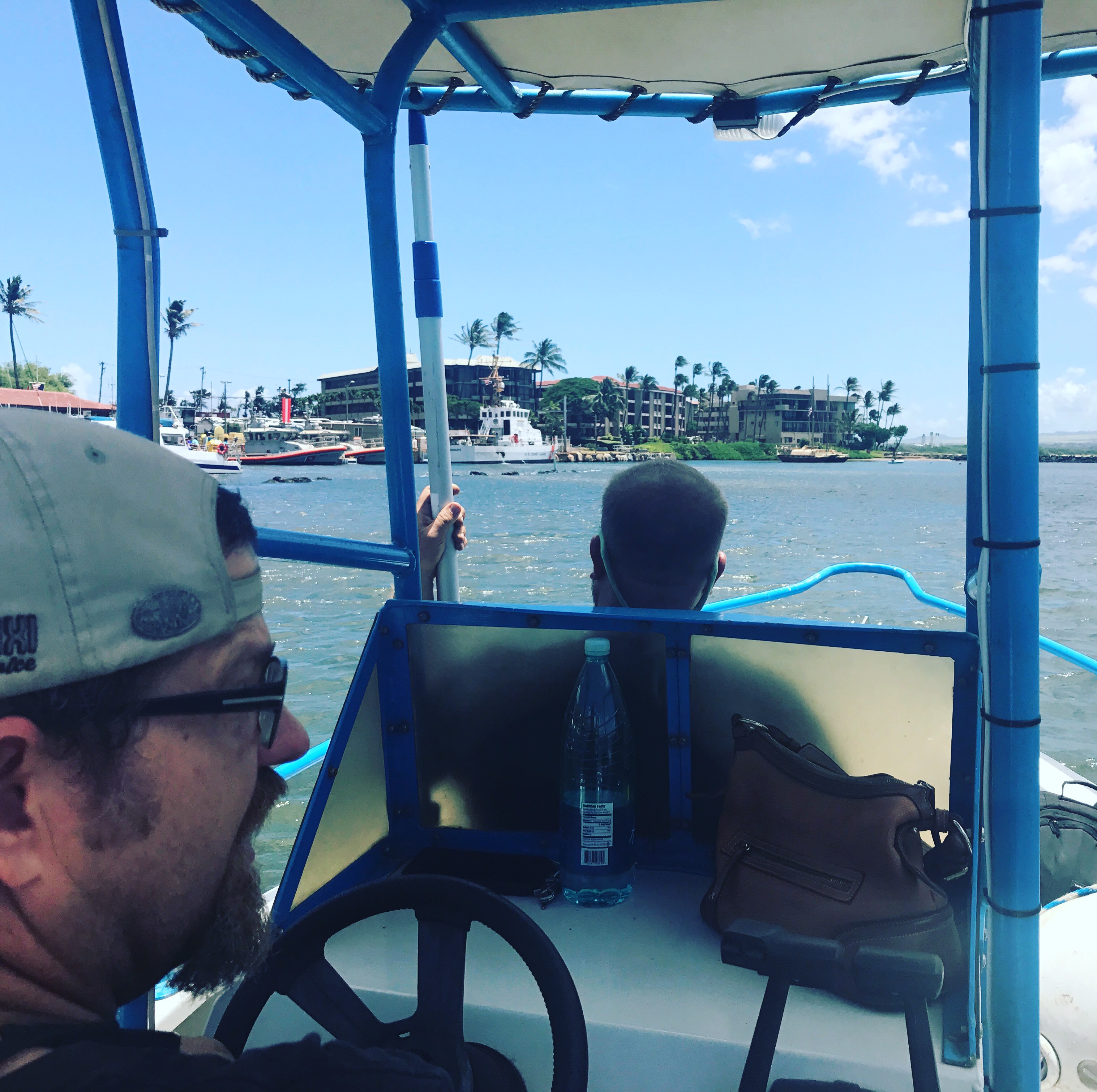 View from a small boat cabin toward a tropical coastline.