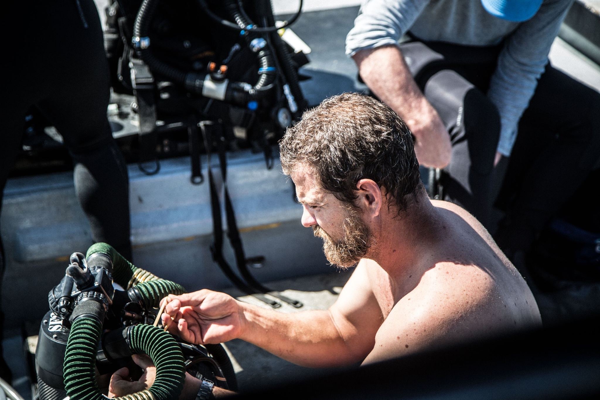Todd Winn working on a rebreather on a boat deck.